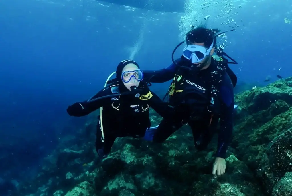 Dive Camp en Tenerife Dos buceadores posando bajo el agua durante una inmersión del campamento de buceo en Tenerife