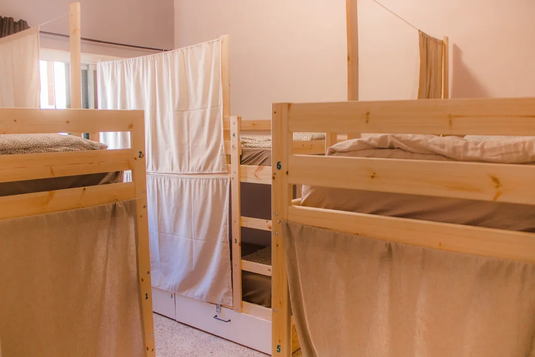 Literas de Single Fin Surf Hostel Literas de madera numeradas con cortinas en una habitación compartida de Single Fin Surf Hostel