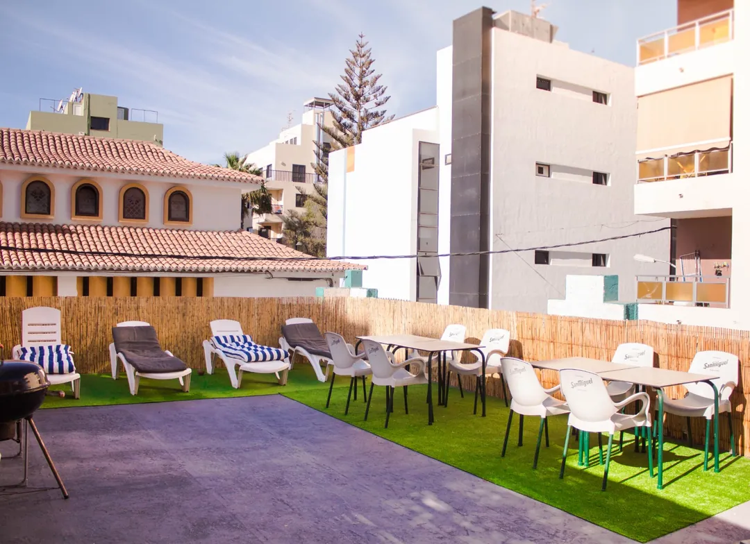 Terraza con barbacoa del hostel Terraza de Single Fin Surf Hostel con barbacoa, tumbonas y mesas para los huéspedes